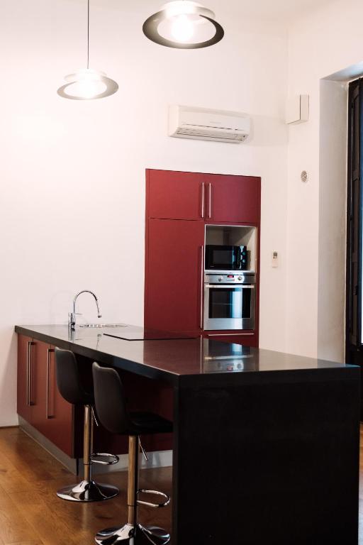 Cucina con mobili rossi e piano di lavoro nero