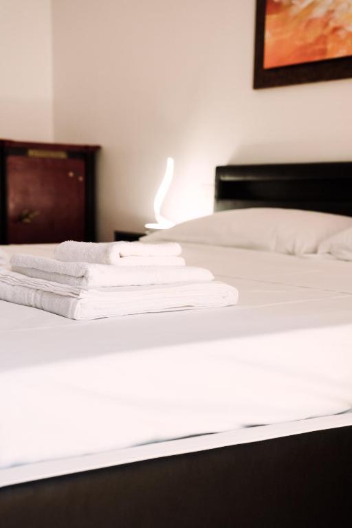 Letto con lenzuola e asciugamani bianchi